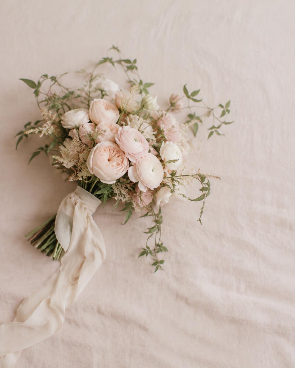 A loose garden bouquet of blush roses tied with cream silk ribbon